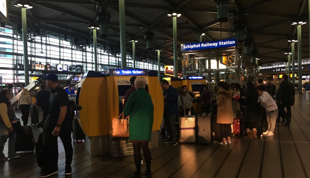 Escalator entrance leading to the train platforms beneath Schiphol Plaza